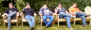 Five young men relax in the unpainted Adirondack chairs.